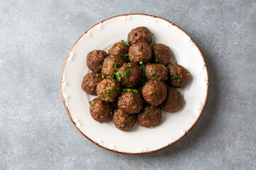 Round shaped balls of dry meatballs and french fries. Turkish name; kuru kofte ve patates