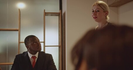 A diverse team of business professionals collaborates on a project, engaging in discussions and analyzing charts in a modern office environment. - Powered by Adobe