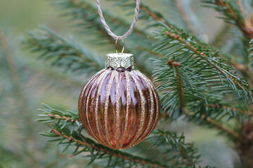 Close-up of a transparent glass brown Christmas ball on a Christmas tree.
