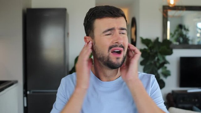 Stressed out man using ear plugs to stop the noise 
