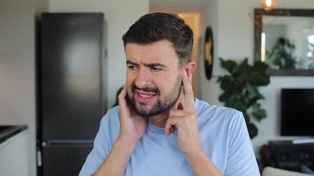 Stressed out man using ear plugs to stop the noise 