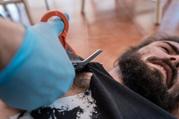 Paramedic using trauma shears cutting clothes of injured patient on floor