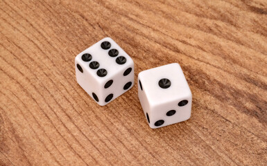 Two white dice showing six and one on wooden surface. Game of chance concept. Symbolizing luck, chance, gambling and probability in games and decision making concepts.