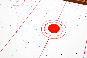 Subject shot of air hockey game table close-up. The portable table hockey includes plastic hockey paddles, a mini puck and score keepers. Hobby game background. Backdrop with copy space. High quality
