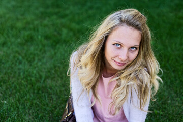 Naklejka premium Young Woman Smiling Playfully on Sunny Lawn in Casual Outfit Copyspace