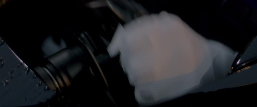 Close-up of a race car driver in a driving fast on a racing track, evening race