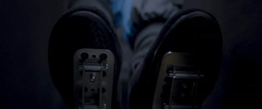 Close-up video of a race car drivers legs and feet engaging the pedals