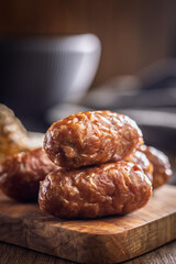 Photo of roasted italian sausage salsiccia on cutting board on wooden table.