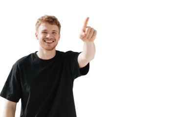 A young man wearing a black shirt is pointing his finger upwards with a smiling expression.