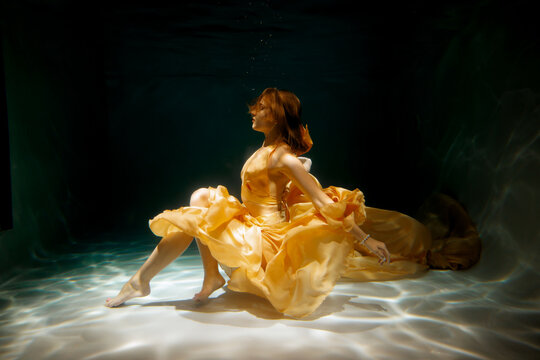 Fototapeta A Graceful Underwater Dance Featuring a Beautiful and Elegant Yellow Dress in Motion