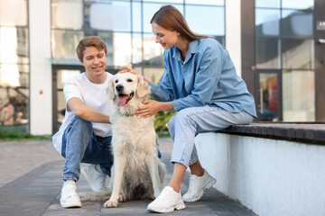 Couple with their adorable golden retriever dog in on city street