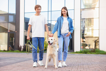 Couple with their adorable golden retriever dog in on city street