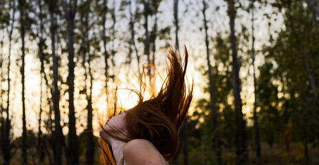 Woman Spinning With Red Hair at Sunset in Forest