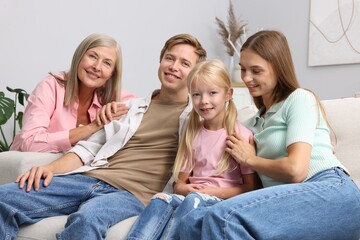 Senior woman with her son's family on sofa at home
