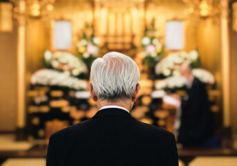 祭壇に向かい故人を偲ぶ高齢男性