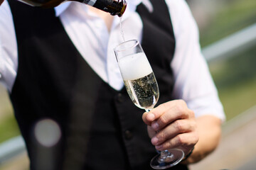 Pouring champagne into elegant glass	