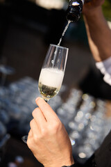 Pouring champagne into elegant glass	