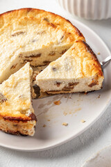 Homemade cottage cheese casserole pie with raisins close up. Baked cheesecake for healthy breakfast on white table background