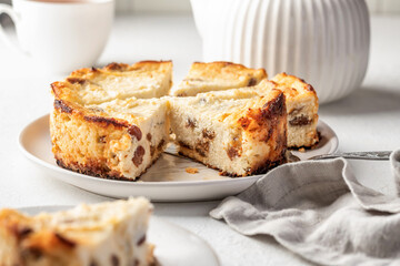 Homemade cottage cheese casserole pie with raisins. Baked cheesecake for healthy breakfast on white table background