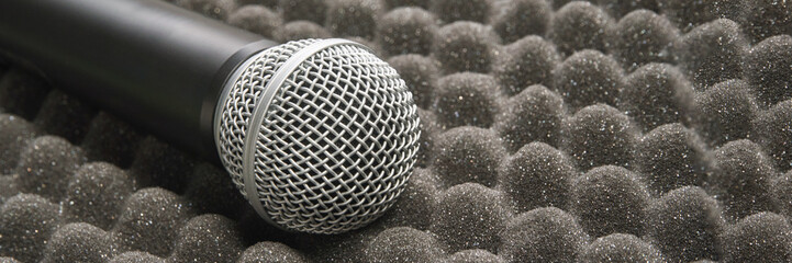 Microphone on acoustic foam surface for sound recording and audio production in studio environments.