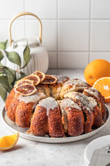 Orange and chocolate marble bundt cake with sugar icing. Fruity citrus dessert on light gray kitchen background