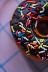 chocolate covered donut with rainbow sprinkles