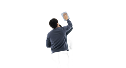 Person meticulously cleaning a wall or surface with a cloth, captured from behind on a plain white background
