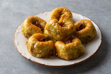 Traditional Turkish dessert called Bulbul Nest , Special baklava with walnut inside and pistachio powder on it, Sherbet dessert which is Turkish name is 'Bulbul Yuvasi'