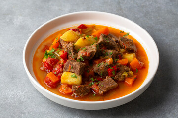 Beef goulash, soup and a stew, made of beef chuck steak, potatoes and plenty of paprika. Hungarian  traditional meal.