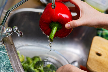 Woman Washing Bell Pepper in Kitchen Sink, Broccoli Soaking for Meal Prep