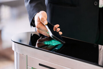 Businessman using smartphone to access secure entry system, demonstrating modern technology and convenience in urban environment with sleek design and innovative features