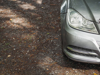 Front of a car parked off road on rough stone surface, selective focus. Nobody. Travel and tourism.