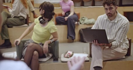 Multiracial business team listens attentively during a presentation in a modern office. Diverse colleagues collaborate, learn and engage with the speaker.