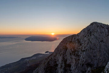 Sunset over sea and rocky mountain ridge