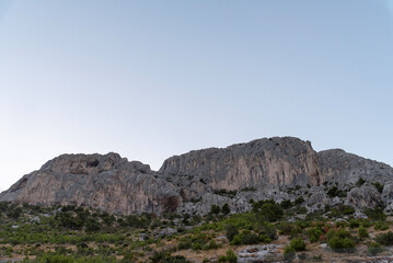 Fototapeta premium Limestone cliff with scrub and clear sky