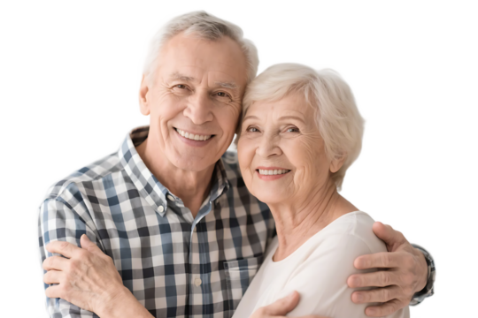 An elderly couple is seen embracing with bright smiles against a plain white background, showing a sense of warmth and affection.