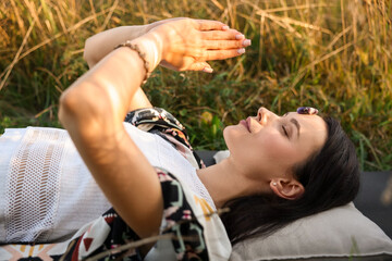 Obraz premium Woman meditating with crystals to heal or restore her aura outdoors
