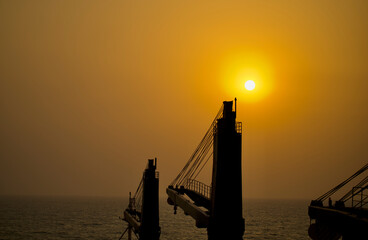 Silhouette of the container ship underway at sea in the morning
