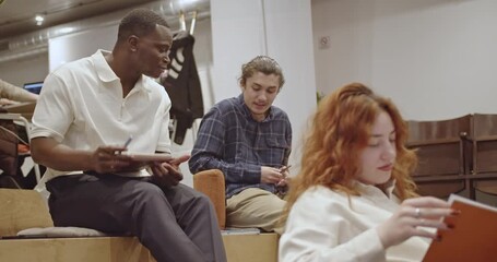 Multiracial colleagues collaborate during a business presentation in a modern office. They actively participate, taking notes and engaging in discussions, showcasing teamwork and knowledge sharing.