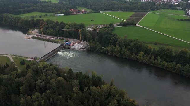 Drone aerial of Landsberg am Lech, Bavaria. Lechstaustufe 15 repaired with fish passages and sustainable river management. Autumn forests and riverside from above