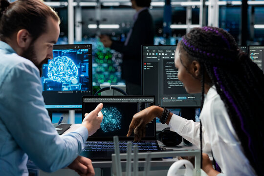 Computer scientists in data center installing upgraded server racks systems helped by AI technology. Server room IT experts upgrading enterprise networks hardware using artificial intelligence - Powered by Adobe