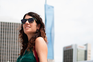 Woman wearing sunglasses looking up in urban city