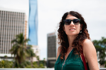 Adult woman wearing sunglasses in urban city landscape