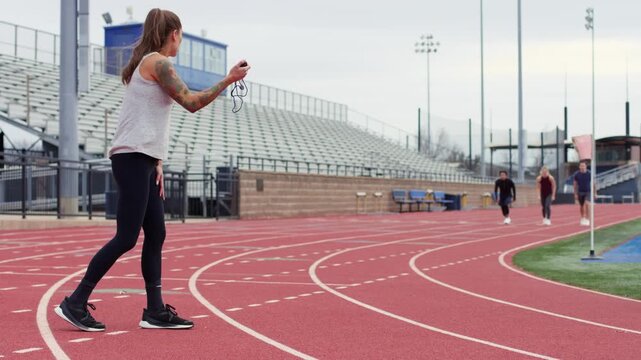 Track and field coach motivates athletes as they sprint energetically towards their running goals.