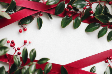 Elegant Christmas background with red ribbon and green leaves festive holiday frame for greeting cards invitations and seasonal designs