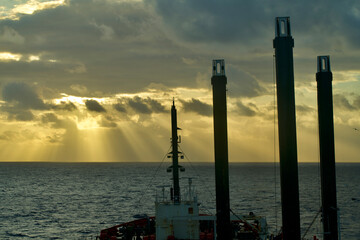 A semi-submersible heavy lift ship underway at sea under dramatic sky