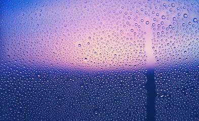 水滴のついた窓越しの風景　夕暮れ　エモーショナル　ノスタルジック　雨上がり　背景　湿気
