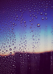 水滴のついた窓越しの青い風景　夕暮れ　エモーショナル　ノスタルジック　雨上がり　湿気　背景