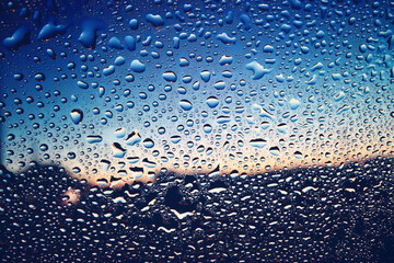 水滴のついた窓越しの青い風景　夕暮れ　エモーショナル　ノスタルジック　雨上がり　湿気　背景