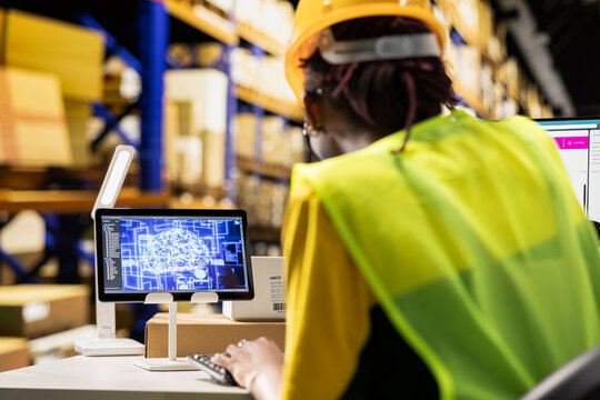 African american woman uses AI deep learning software for e-commerce automation, working in distribution hub with neural networks brain managing tracking software in warehouse. Data science. - Powered by Adobe